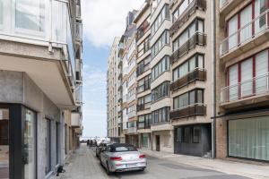 a car parked on a street between buildings at Luxe zeeverblijf op 1min van het strand - 5p in Knokke-Heist