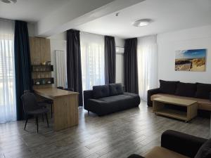 a living room with a couch and a table at Apartament Ella C&C Residence in Mamaia Sat/Năvodari