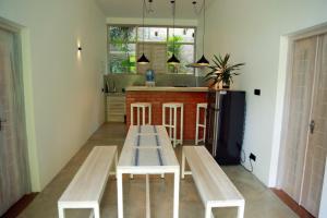 a kitchen with a table and benches in a room at Jack & Rose - Hiriketiya, Haven Garden Properties in Dickwella