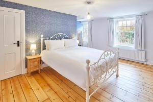a bedroom with a white bed and a blue wall at Host & Stay - Kenmore in Corbridge