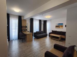 a living room with a couch and a table at Apartament Ella C&C Residence in Mamaia Sat/Năvodari