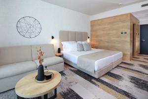 阳光海滩Hotel Marvel All Inclusive - FULLY RENOVATED FREE Beach Access的一间酒店房间，里面有一张床和一张沙发