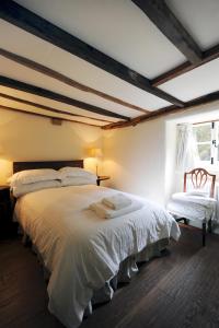 a bedroom with a large white bed and a window at Park CottageChatsworth Estate in Baslow +2 photos