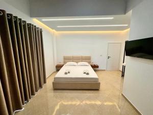 a bedroom with a bed in a room with curtains at Dine Hotel in Ksamil