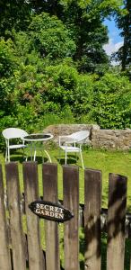 a wooden fence with two chairs and a table at Primrose Cottage in Helston