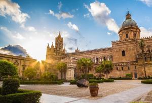 a large building with a clock tower and a cathedral at Menzel el Emir in Misilmeri