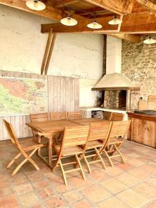 a dining room with a wooden table and chairs at Evasion enchantée, maison au cœur de la forêt in Léogeats