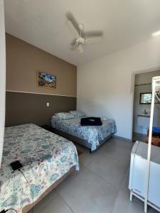 a bedroom with two beds and a ceiling fan at Suítes Laure in Lindóia