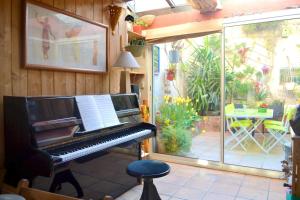 a piano sitting in a room with a patio at Maison charmante près d'Avignon avec terrasse in Avignon
