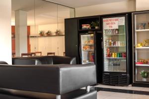 a restaurant with chairs and a refrigerator with food at Vidagi Palace Hotel in Nova Serrana