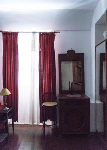 a room with red curtains and a mirror and a chair at Giunio house, Old town centre in Korčula +14 photos