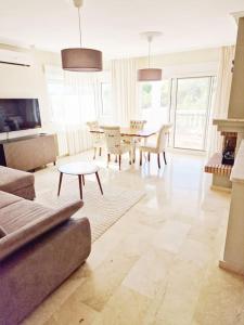 Una sala de estar con un sofá, una mesa y sillas. en Always sunny apt PoolGolfBeach, en Alicante 17 fotos más