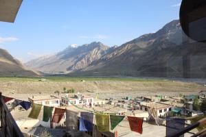 a view of a village with clotheslines and mountains at Hotel Spiti Heritage in Kaza