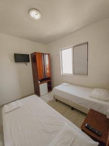 a hotel room with two beds and a television at Vidagi Palace Hotel in Nova Serrana +18 photos