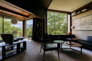 箱根町にあるAKNOT hakone 大涌谷を望むモダニズム建築 東京から90分のソファとテーブルのあるリビングルーム