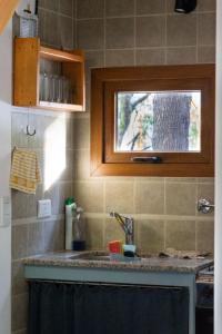 Una encimera de cocina con un fregadero y una ventana. en Casa en el Bosque, en San Carlos de Bariloche