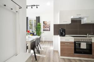 ミュンヘンにあるApartment an der Theresienwieseのキッチン(白いキャビネット、ダイニングテーブル付) +14枚の写真