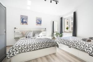 ミュンヘンにあるApartment an der Theresienwieseの白い壁のベッドルーム1室(ベッド2台付)