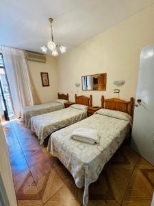 a room with three beds in a room at Hostal Fuentesol in Madrid