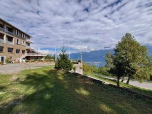 a view of a building with a tree in the grass at PROVINCIALE 79 in Magreglio