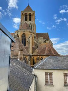 una vecchia chiesa con una torre e un edificio di Studio, au cœur de St pierre sur dives a Saint-Pierre-sur-Dives