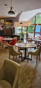 a restaurant with tables and chairs in a room at Hotel Le Circuit Le Mans in Le Mans