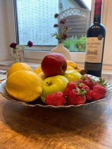 a bowl of fruit on a table with a bottle of wine at Ferienwohnung Katharina in Mastershausen +29 photos