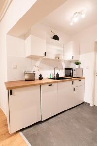 a kitchen with white cabinets and a counter top at Hamburg City Apartment for 5 in Hamburg