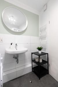 a white bathroom with a sink and a mirror at Hamburg City Apartment for 5 in Hamburg +14 photos