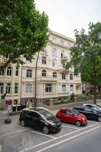 three cars parked in a parking lot in front of a building at Hamburg City Apartment for 5 in Hamburg