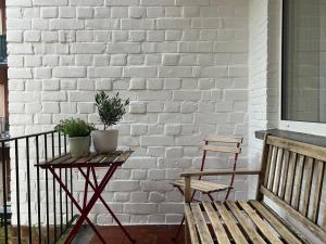 a bench and a table with two plants on a balcony at House of Legend in Antwerp