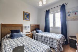 a bedroom with two beds and a laptop on it at 3 Bed Beach Apartment with views Isla Canela in Isla Canela