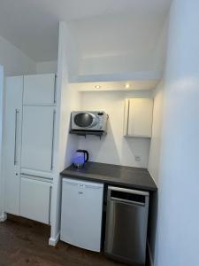 eine kleine Küche mit Spüle und Mikrowelle in der Unterkunft Rachelle in Blankenberge + 8 Fotos