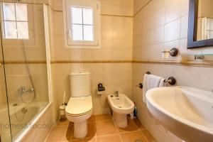 a bathroom with a toilet and a tub and a sink at 3 Bed Beach Apartment with views Isla Canela in Isla Canela +16 photos