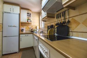 a kitchen with a white refrigerator and a sink at 3 Bed Beach Apartment with views Isla Canela in Isla Canela