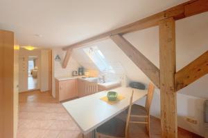 a kitchen and dining room with a white table at Haus Antje Studio in Kölpinsee