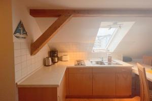 a small kitchen with a sink and a window at Haus Antje Studio in Kölpinsee