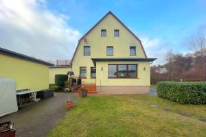 a yellow house with a gambrel roof at Haus Antje Studio in Kölpinsee