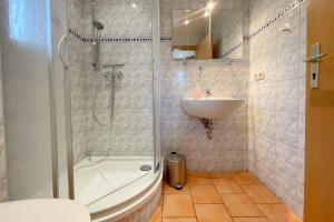 een badkamer met een douche en een wastafel bij Haus Antje Gartenbungalow in Kolpinsee +21 foto's