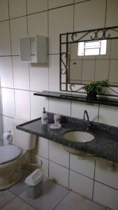 ein Badezimmer mit einem Waschbecken, einem WC und einem Spiegel in der Unterkunft Pousada Vaca Brava in Areia