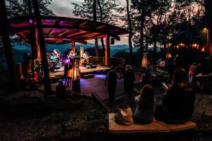 a group of people sitting around a stage at night at Wine Down at Eagles Nest in Elk Park