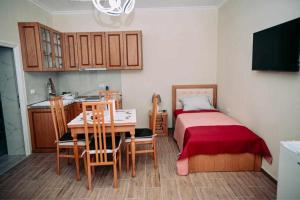 Un dormitorio con una cama y una mesa y una cocina. en Vila BENE, en Pogradec
