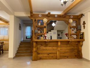 aoyer with a wooden bar with a mirror and stairs at Pensiunea Valea Muntelui in Bîrsana