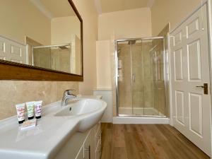 a bathroom with a sink and a shower and a mirror at Vernon Guesthouse in Eastbourne +62 photos