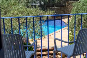 two chairs on a balcony with a swimming pool at Hotel Blaumar Cadaqués by Fimedhotels in Cadaqués
