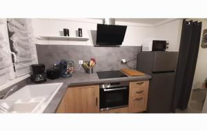 a kitchen with a sink and a black refrigerator at A 200 m BEACH in Sangatte