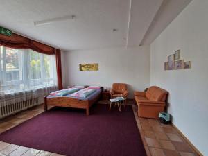 a bedroom with a bed and a couch and a chair at Pension Antalya in Friedrichshafen