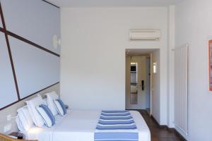 a bedroom with a bed with blue and white pillows at Hotel Blaumar Cadaqués by Fimedhotels in Cadaqués