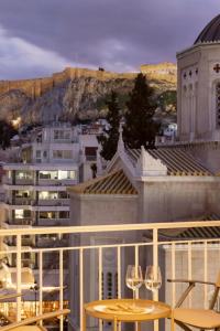 a view of a city from a balcony with wine glasses at Meliti Apartment in Plaka in Athens