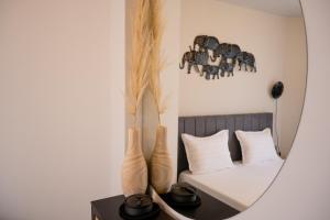 a mirror on a table with two vases at Dion Apartments in Lozenets